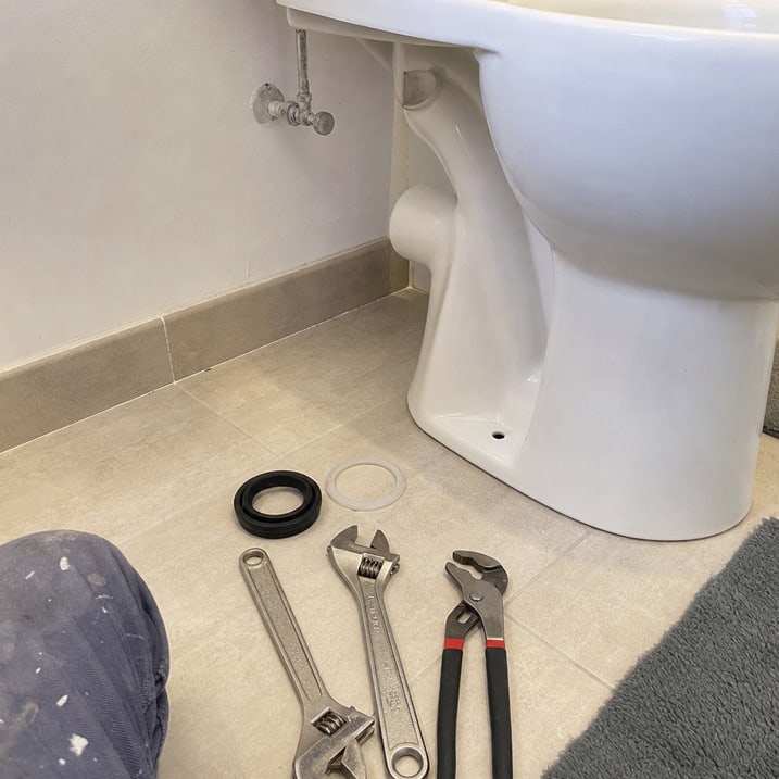 outillage posé près cuvette de WC sur sol carrelé